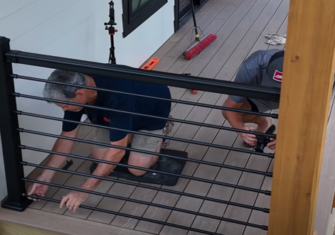 Close up of installing black horizontal balusters on a deck