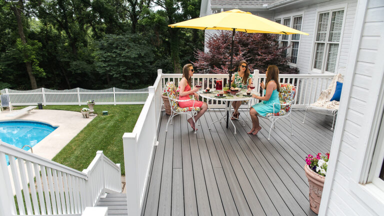 Outdoor living space featuring white pool deck railing.